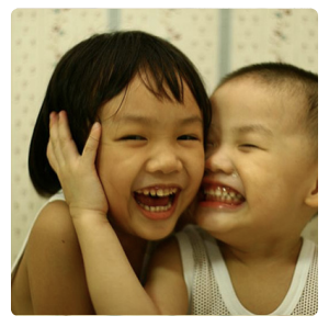 A photo of a young boy and girl hugging and smiling